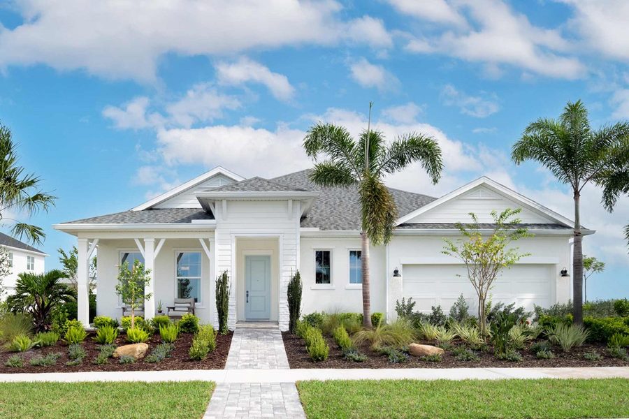 A new coastal-style single-family home in SeaFlower with a white front porch and palm trees